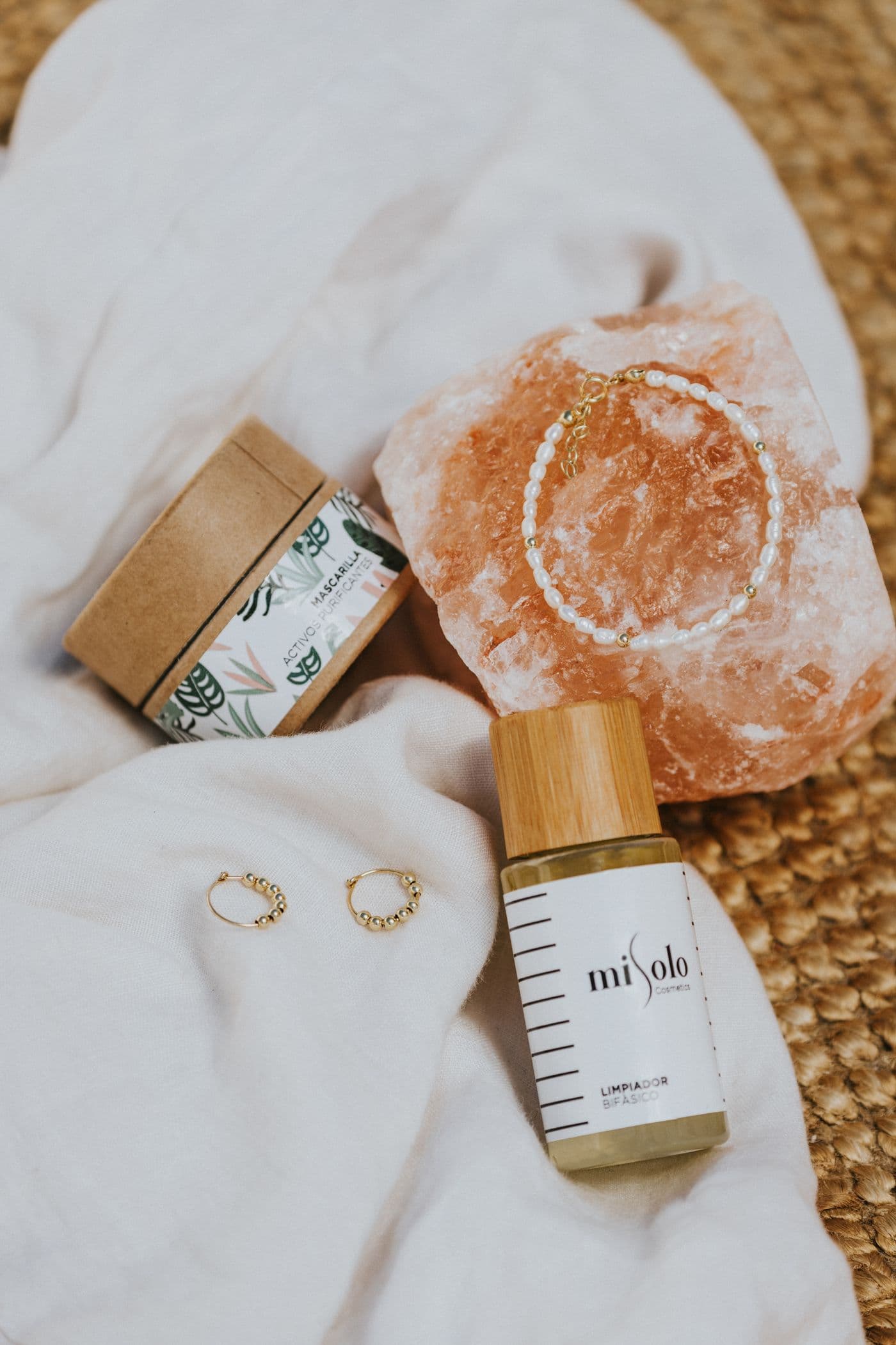 Jewelry and self-care pieces on soft fabric